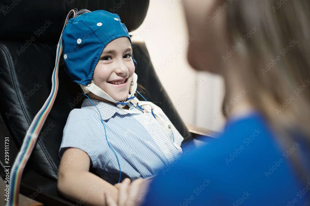 Portrait of Smiling Autistic Girl Undergoing an EEG Examination